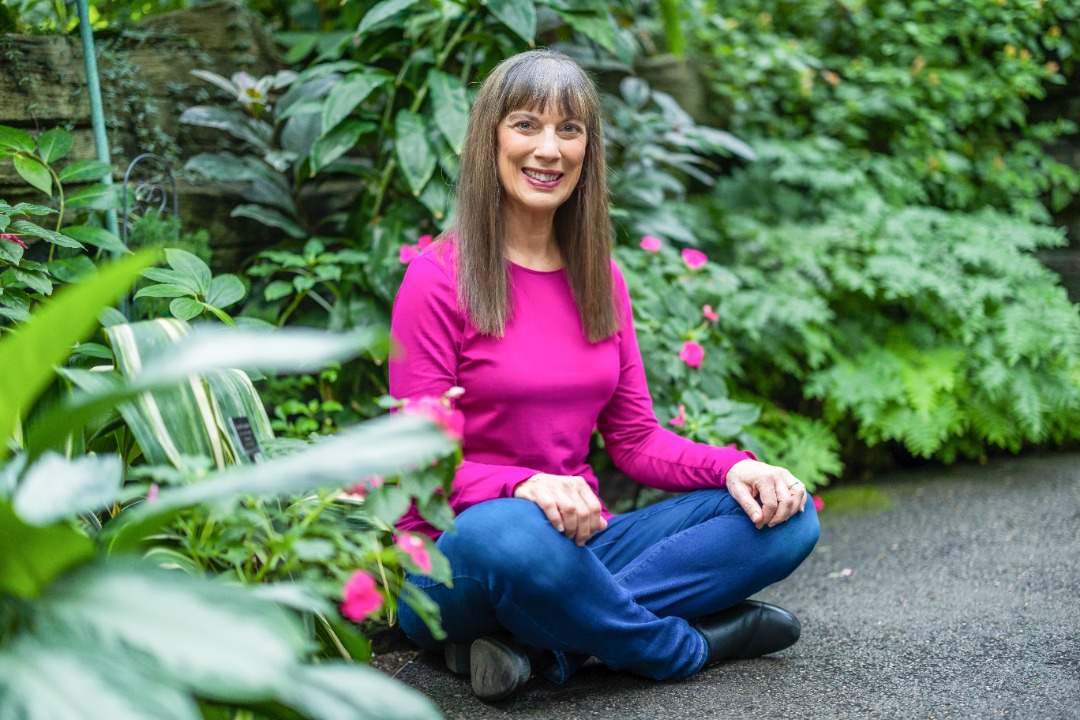 Joyful woman in a garden, exuding wellness, joy, and vibrant natural beauty.